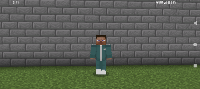 Character in teal tracksuit by brick wall.