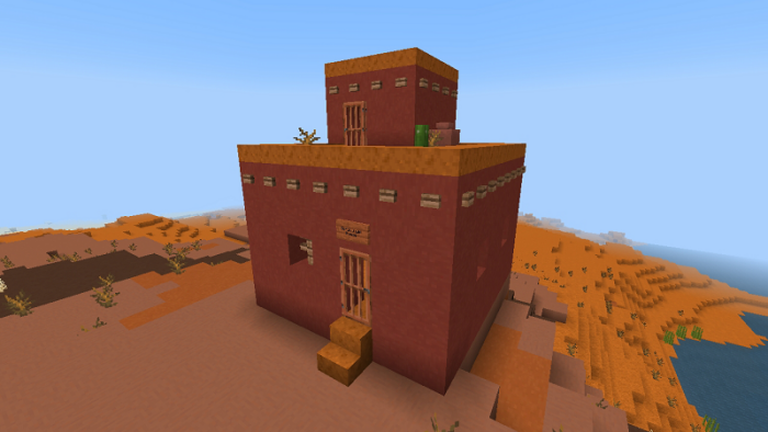 Red desert building with flat roof.