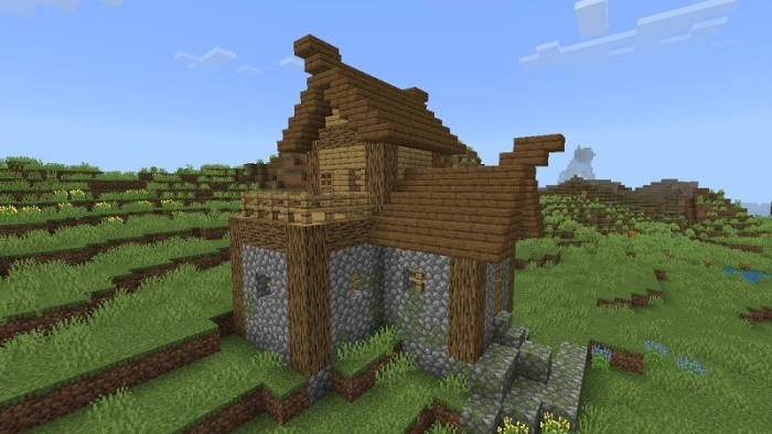Rustic wooden house on grassy landscape.