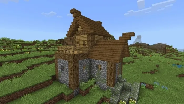 Rustic wooden house on grassy landscape.