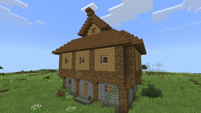 Wooden house on a grassy field.