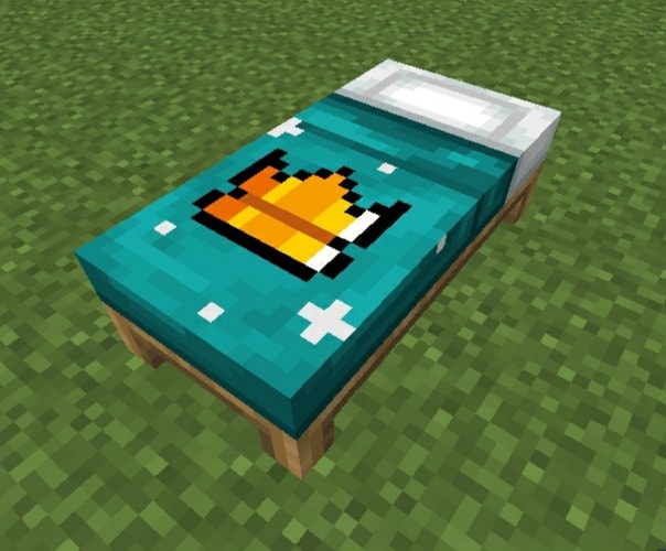 A bed with a crown design on teal sheets.