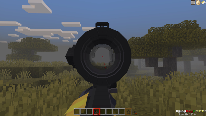 Gun scope view in a grassy terrain.