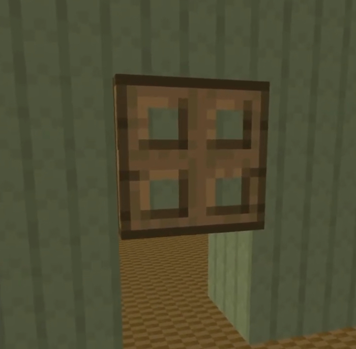 Wooden trapdoor on green wall.