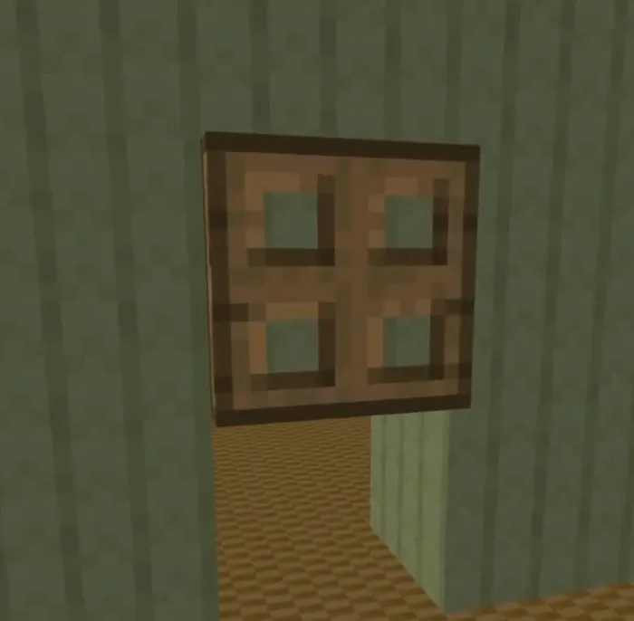 Wooden trapdoor on green wall.