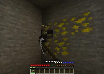 Player mining yellow ore with iron pickaxe