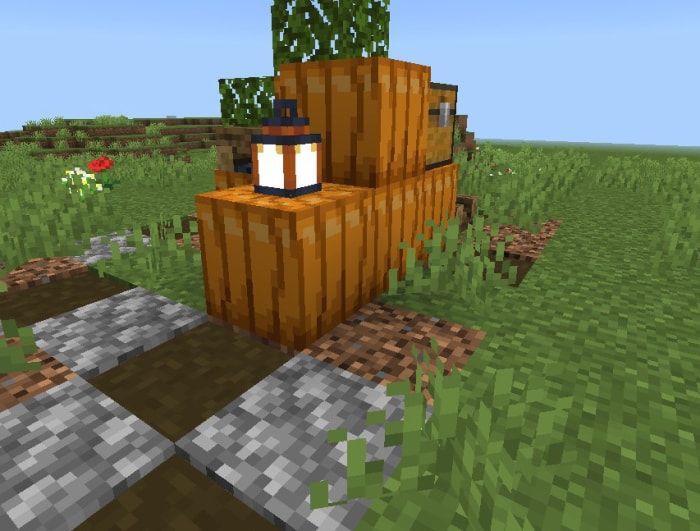 Pumpkin and lantern structure in grass.