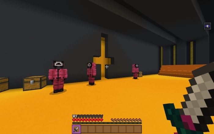 Three masked guards in a golden room