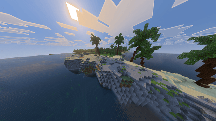 Sunlit island with trees and ocean.