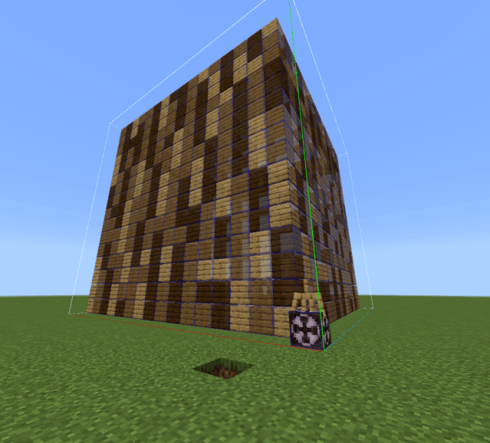 Large cube of oak planks on grassy field