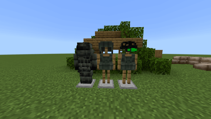 Three military armor sets on stands outdoors