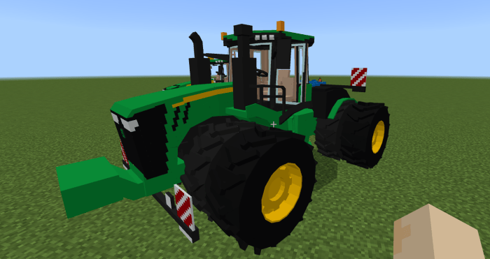 Blocky green tractor on grass field.