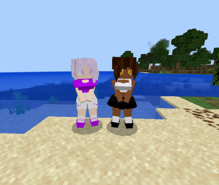 Two mermaid characters on a beach.
