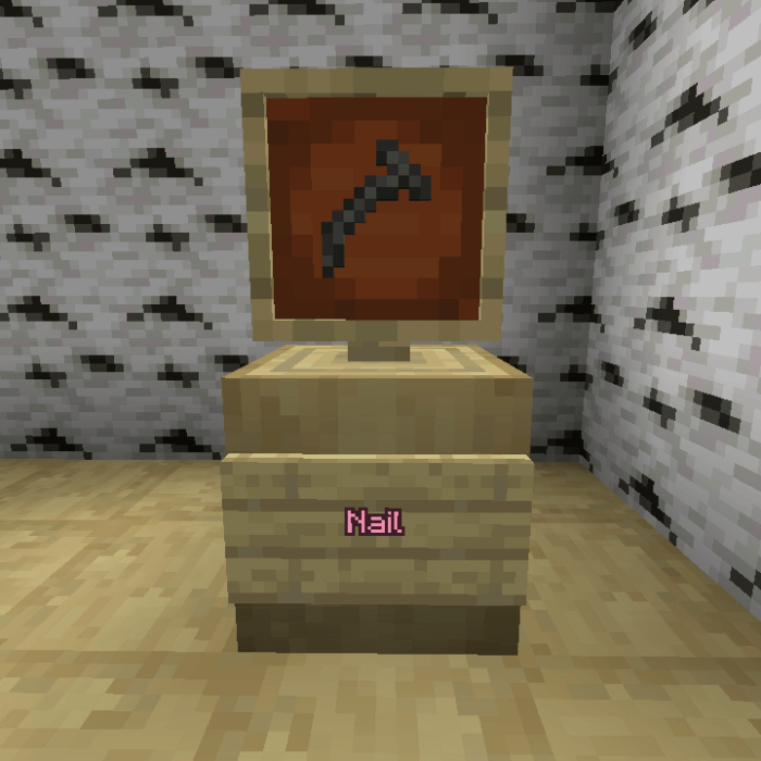 Nail item displayed in a wooden frame.
