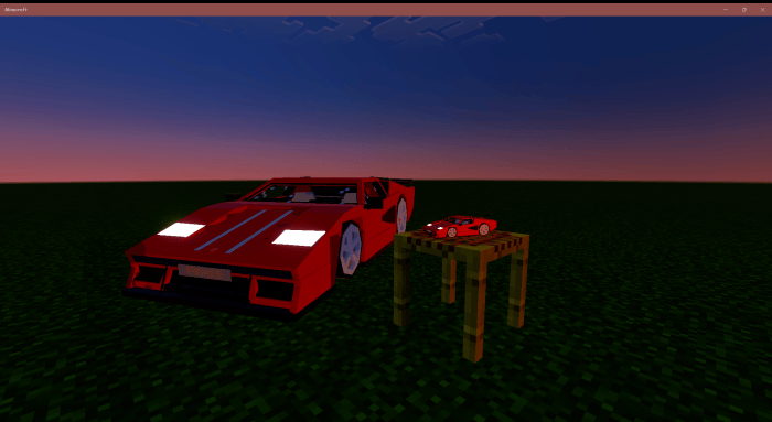 Red car and model car on a table.