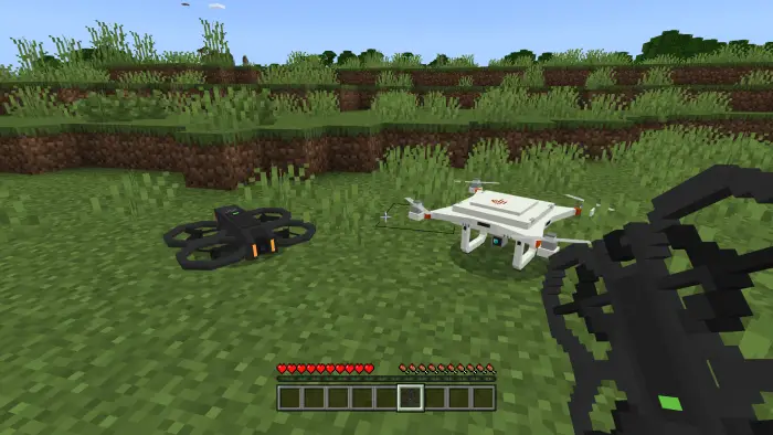Two drones on grassy terrain, player holding controller
