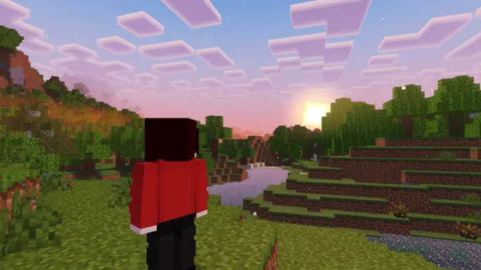 Blocky character watches a vibrant sunset