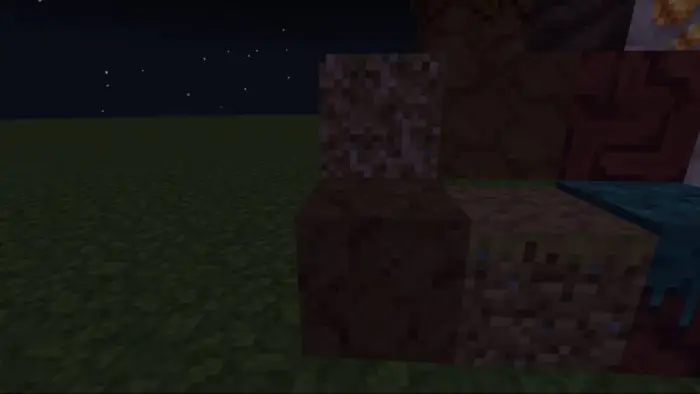 Four textured blocks on grass at night