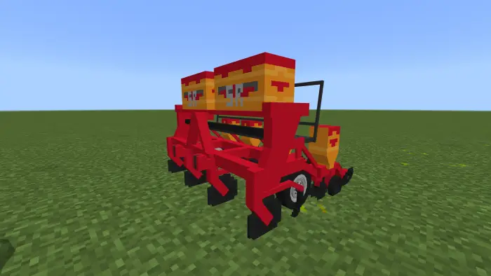 Red farming implement on grassy field