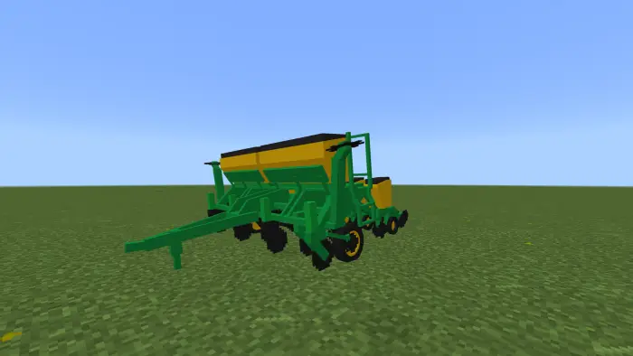 Green and yellow seeder on grassy field
