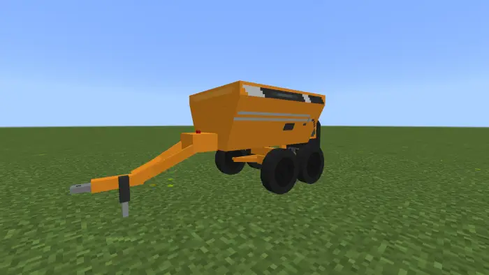 Yellow farm trailer on grassy terrain