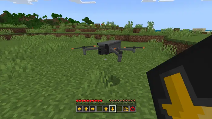 Drone hovering above grassy terrain