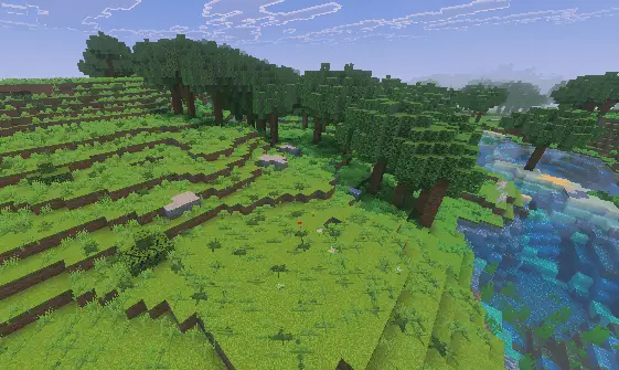 Lush grassy hills with dense forest and river