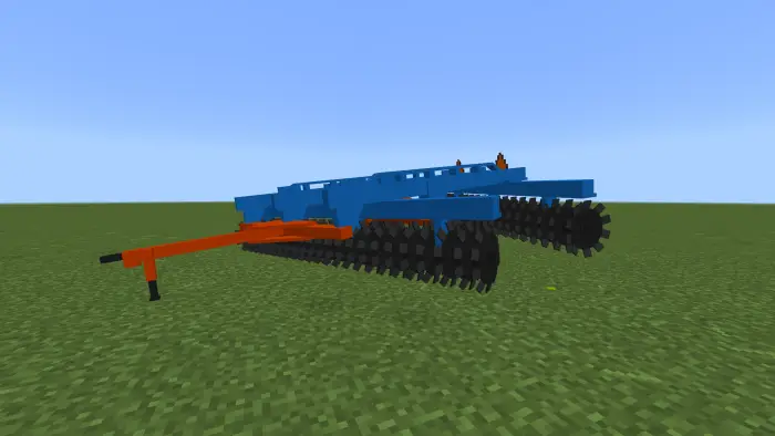 Blue and orange farm implement on grass field