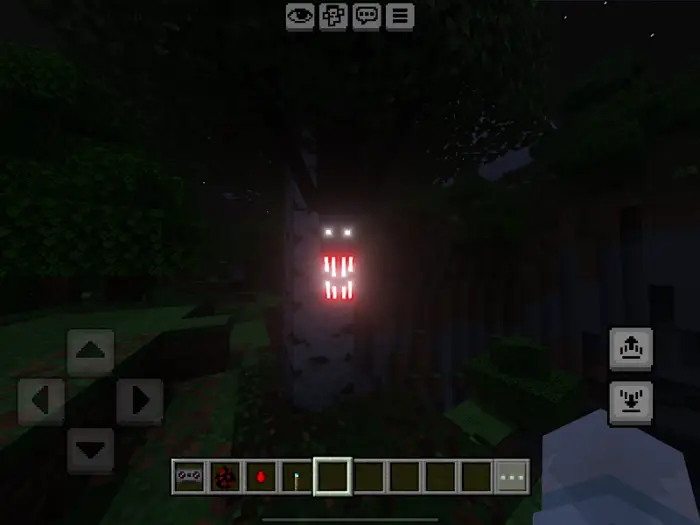 Tree with glowing eyes and sharp teeth at night