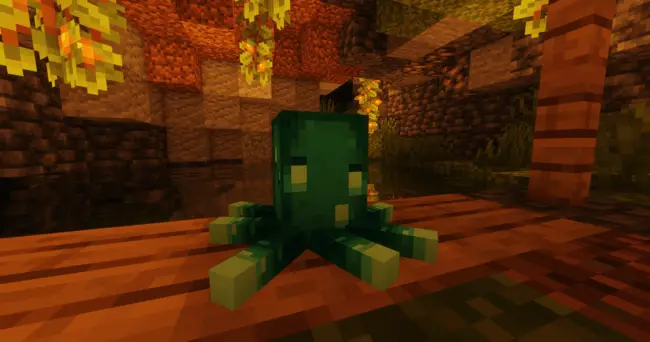 Green plush squid on wooden table