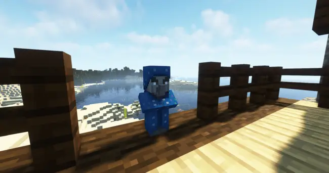 Blue plushie figure standing on wooden deck