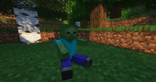 Plush zombie toy sitting on grass.