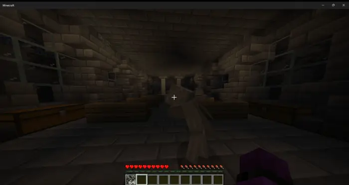 Dimly lit underground stone hallway with chests
