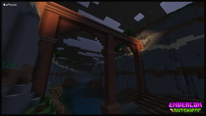 Stone bridge arches over a river at night.