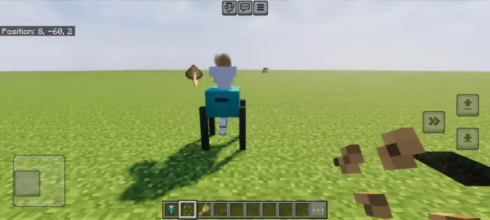 Blocky character sits on a blue chair outdoors.
