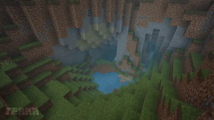 Lush cave with grass, water, and cliffs