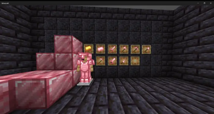 Pink armor and tools displayed in a stone room.