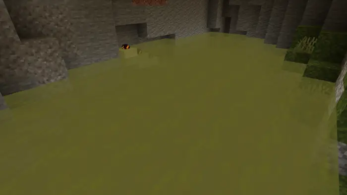 Yellow rubber duck floats in murky water.