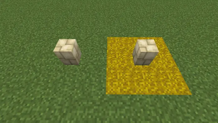 Two stone posts, one on yellow hay block