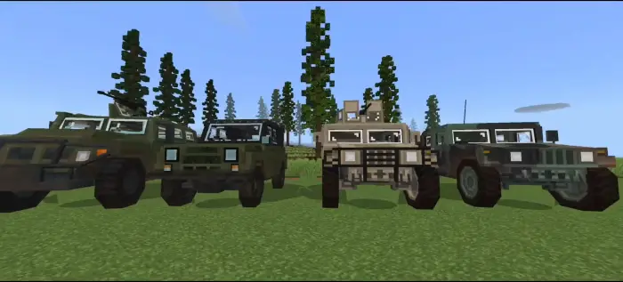 Four military vehicles lined up on grass