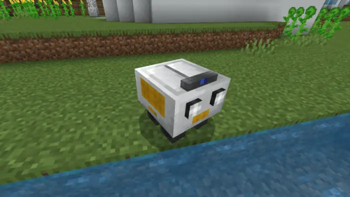 Small white robot by a riverbank