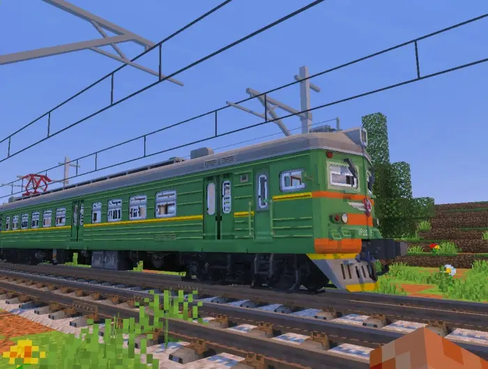 Blocky green train on rural railway tracks