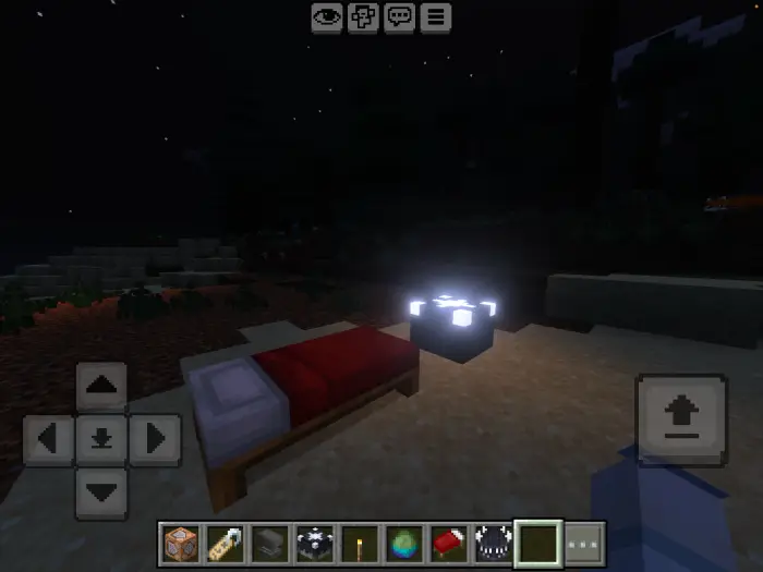 Bed and glowing block at night in-game.