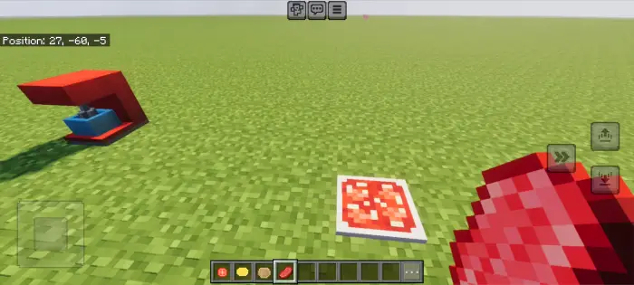 Red appliance and food items on grass block