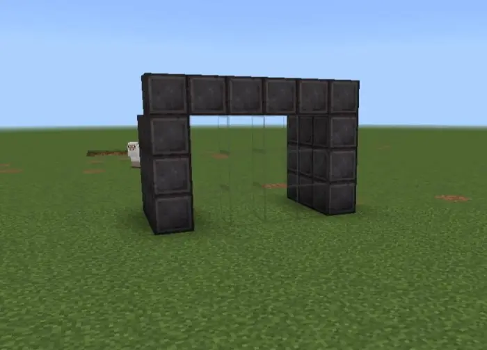 Black block archway stands on grassy field