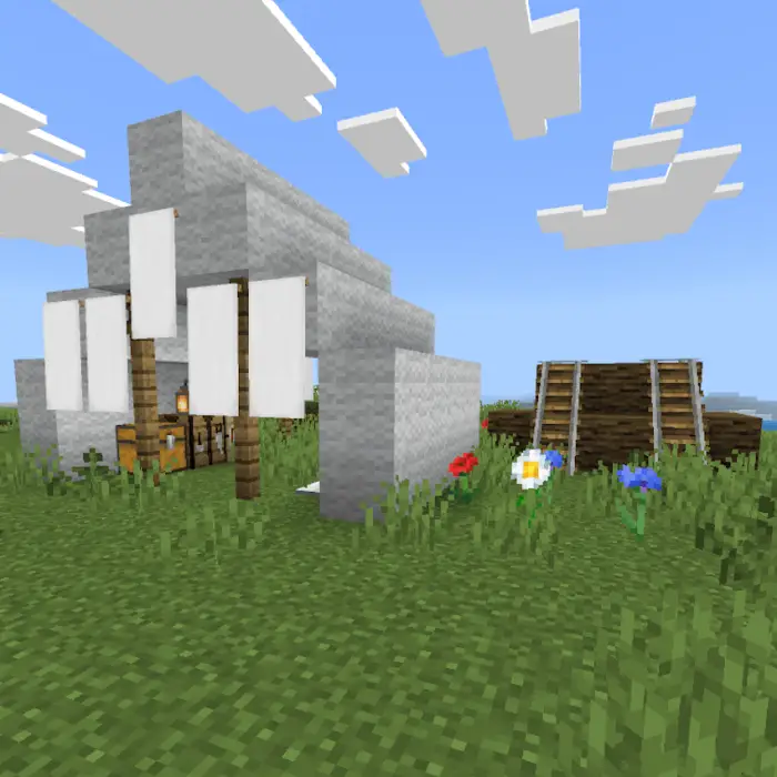 White tent and wooden structure on grass.