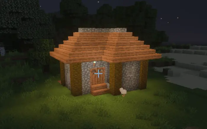 Small stone and wood house lit at night