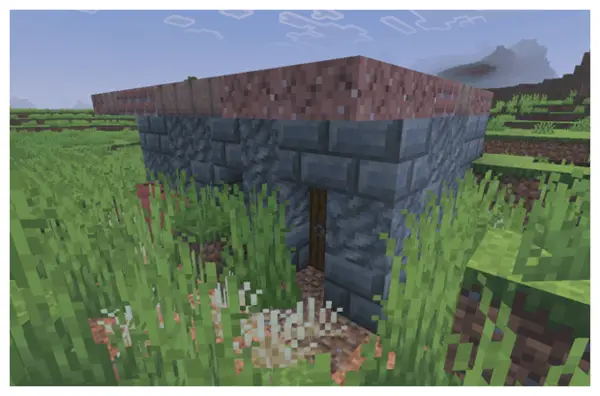 Small stone shelter in overgrown grass