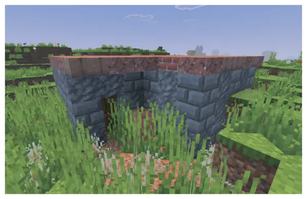 Overgrown stone bunker in grassy field