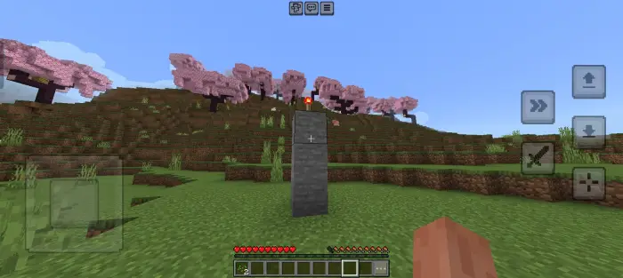 Stone pillar with torch in grassy field